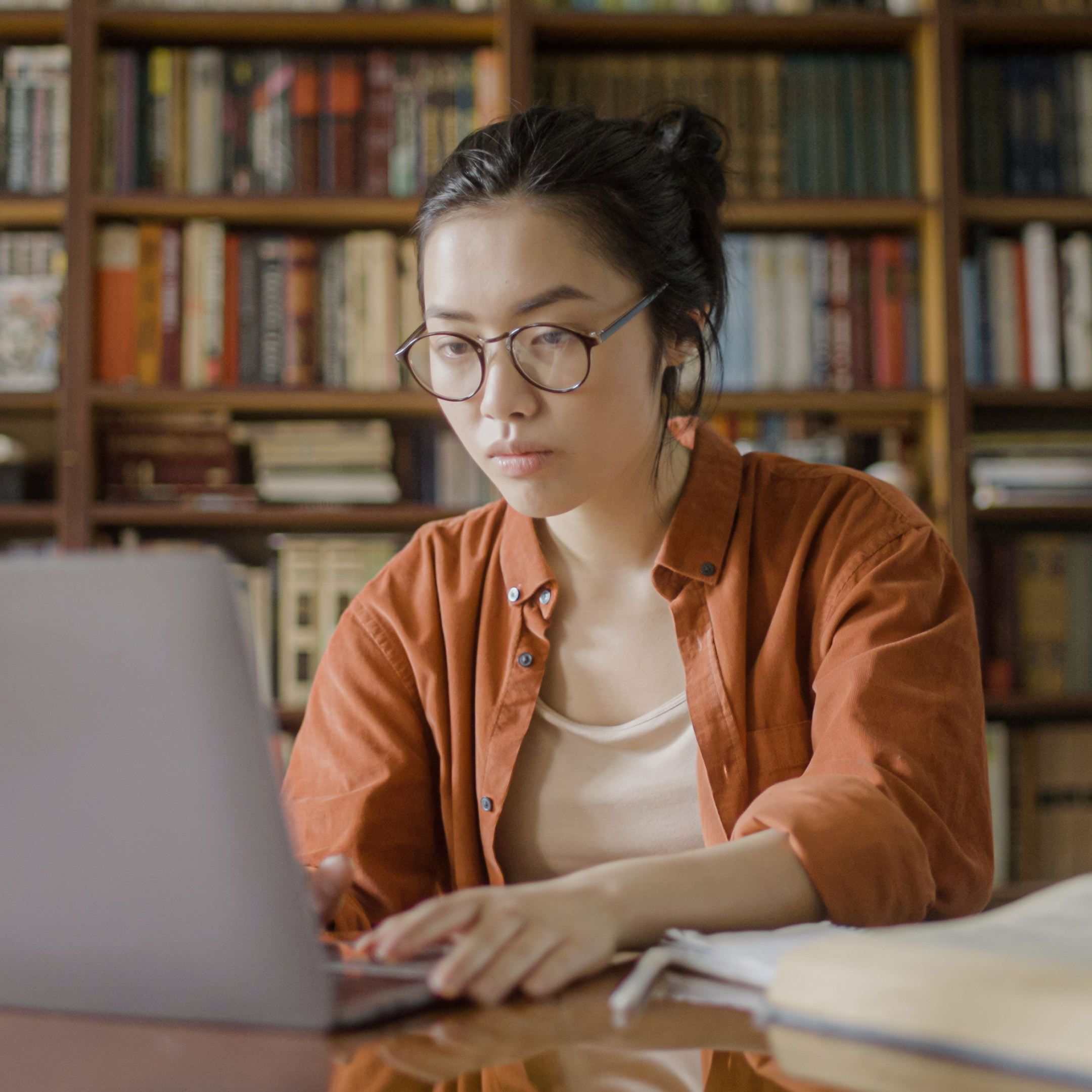 Female student studying at a desk with a laptop. 